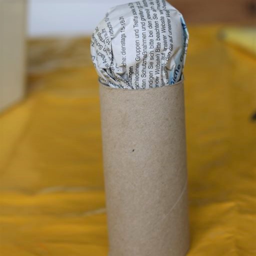 Presser et torsader du papier pour fabriquer une forme de tete pour le fetiche a voeux