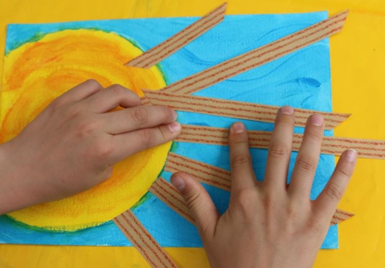 Coller les bandes de papier pour faire les rayons du soleil.