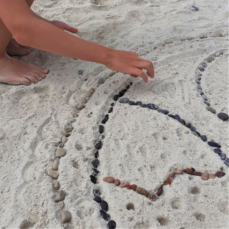 Beach art: poser les petits caillous par couleur pour faire un mandala