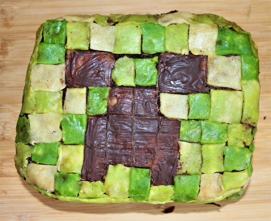 Gateau d'anniversaire au chocolat recouvert de mosaique de pate d'amande, representant un creeper de Minecraft.